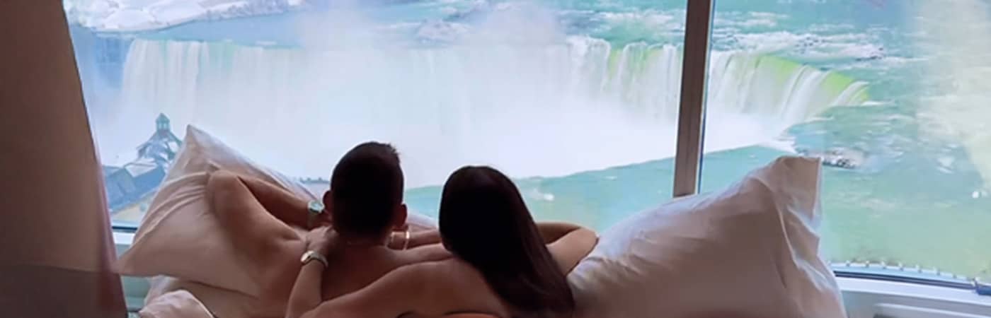 Couple looking at the Falls from their room at Marriott Fallsview